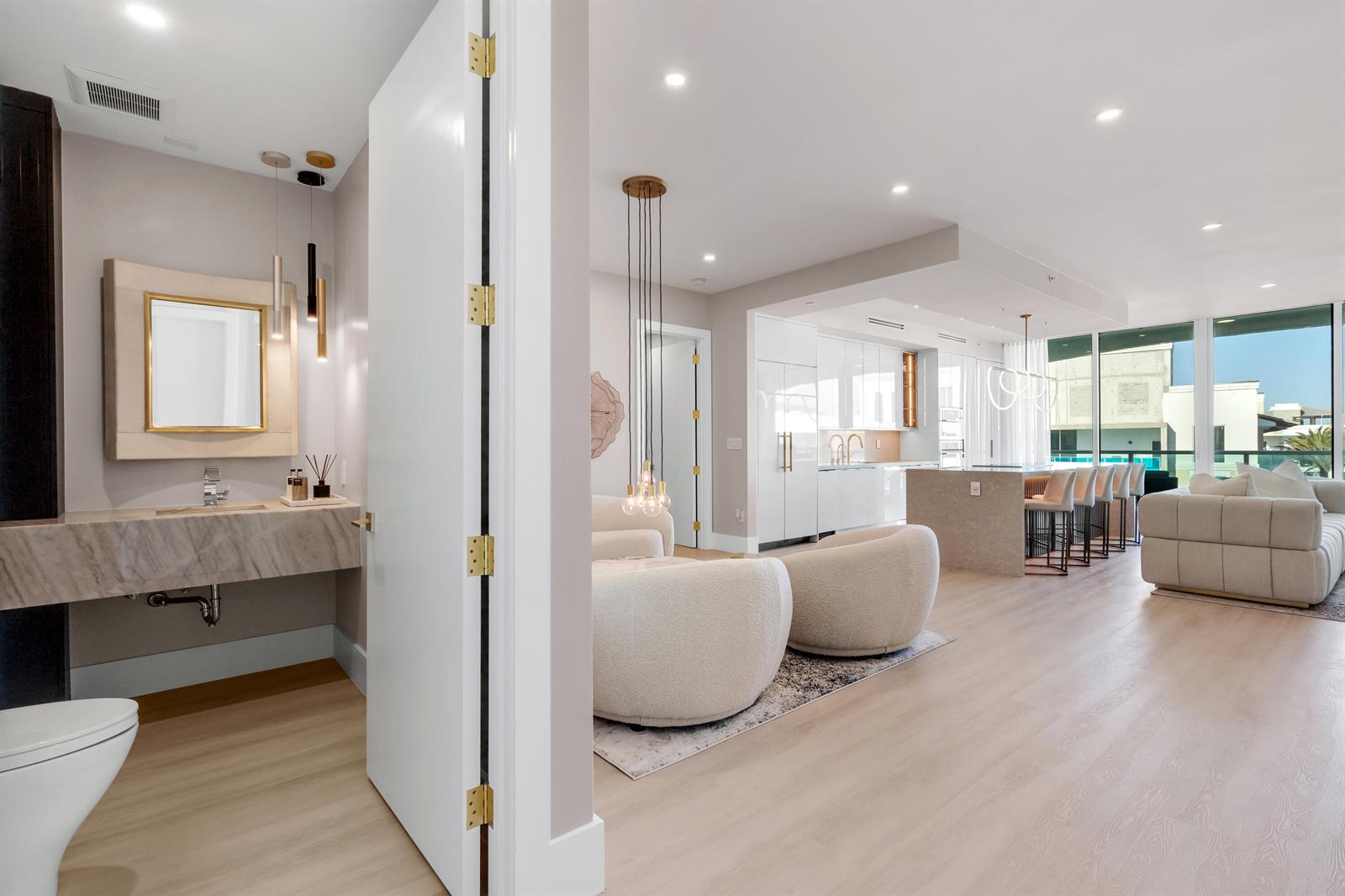 A modern open-concept living area features a kitchen, lounge, and a separate powder room — 500 SE Mizner Boulevard # A902, Boca Raton FL 33432, BOCA RATON, FL