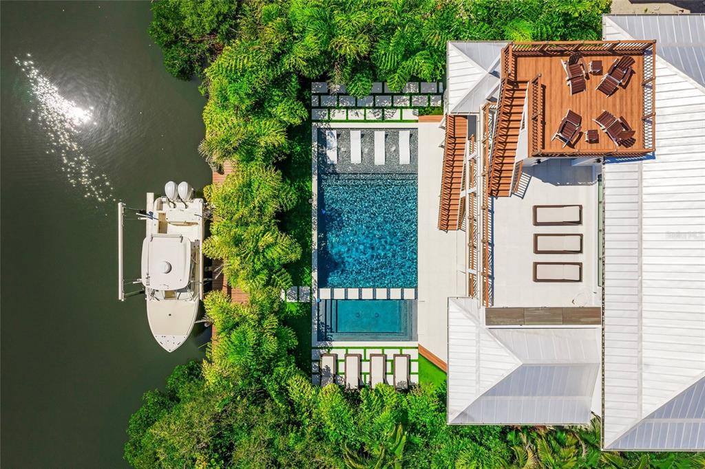 An aerial view shows a house with a pool, a rooftop deck, and a boat — 209 WILLOW AVENUE, ANNA MARIA, FL