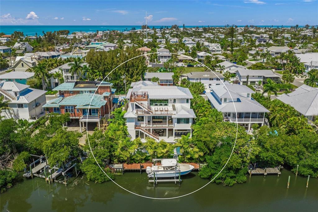 An aerial view of a multi-story waterfront house with a private boat dock and lift — 209 WILLOW AVENUE, ANNA MARIA, FL