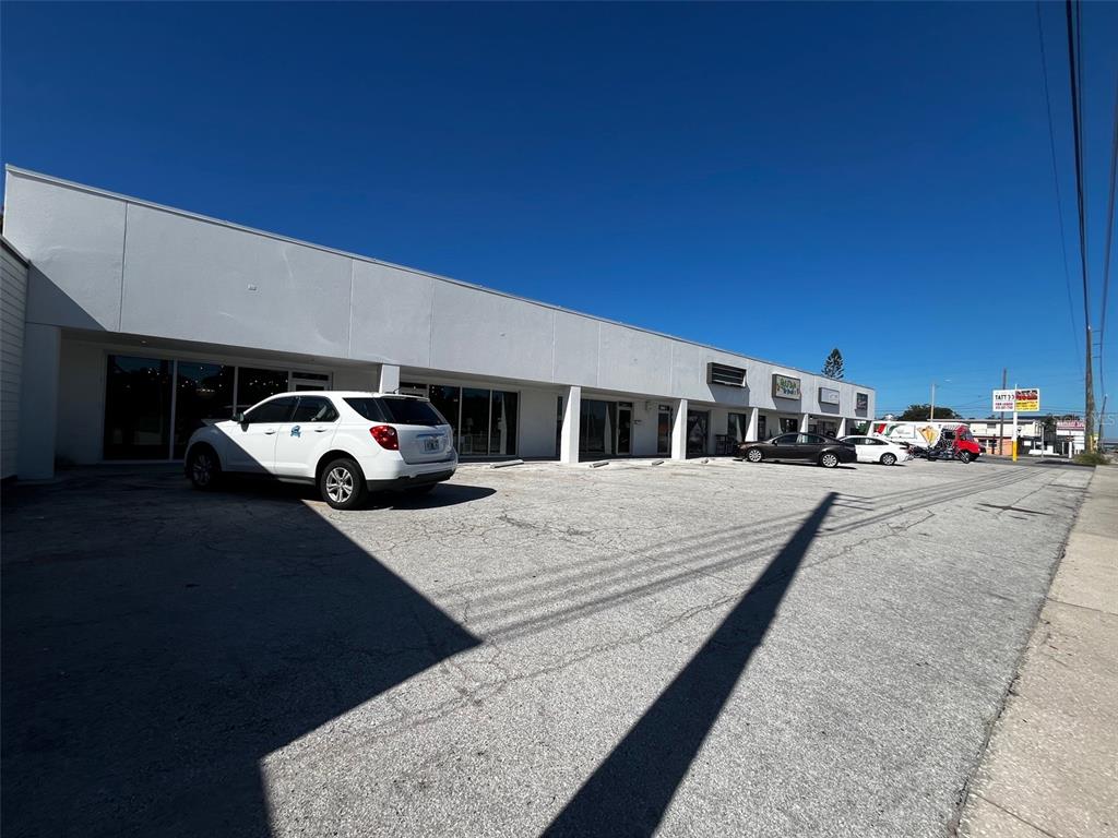 A white, single-story commercial strip mall building with a large asphalt parking lot in front — 6020 SEMINOLE BOULEVARD, SEMINOLE, FL