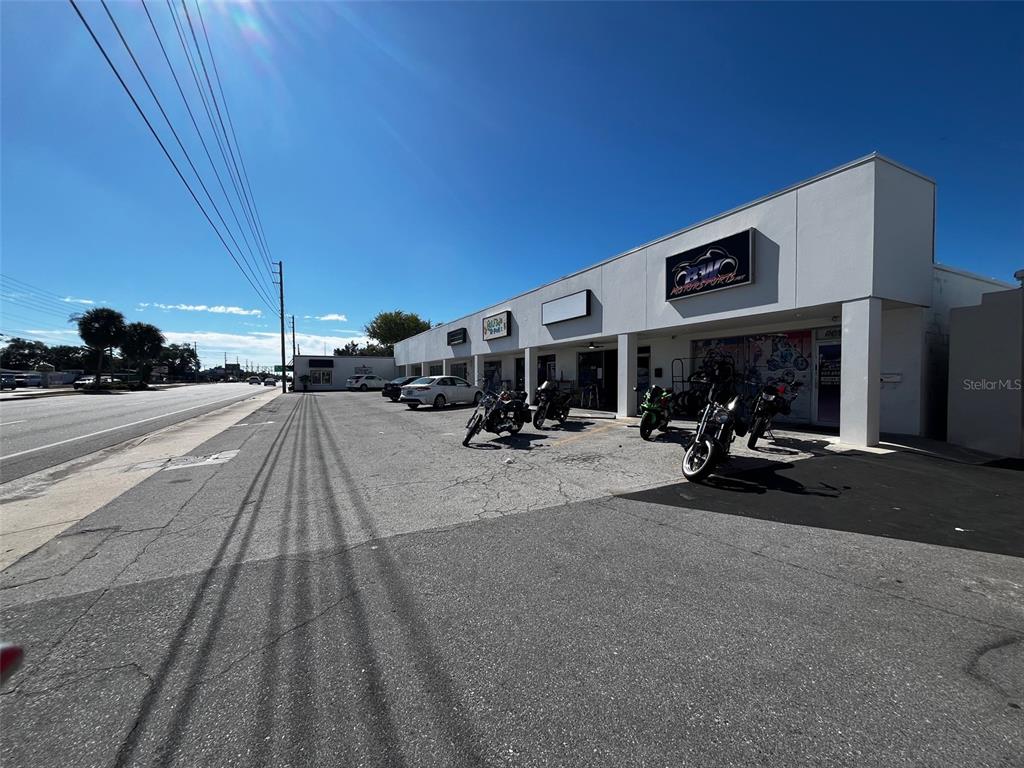 A commercial building exterior features a parking lot with several motorcycles and parked cars — 6020 SEMINOLE BOULEVARD, SEMINOLE, FL