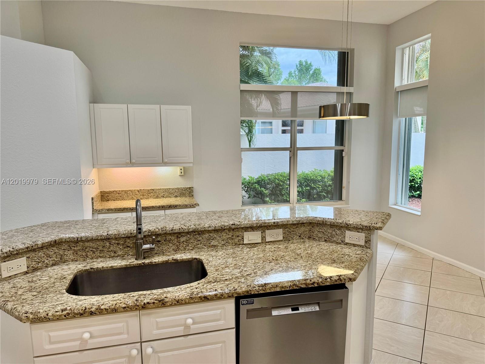 A kitchen features granite countertops, white cabinets, a stainless steel dishwasher, and large windows — 2525 Bay Pointe Ct, Weston FL 33327, WESTON, FL