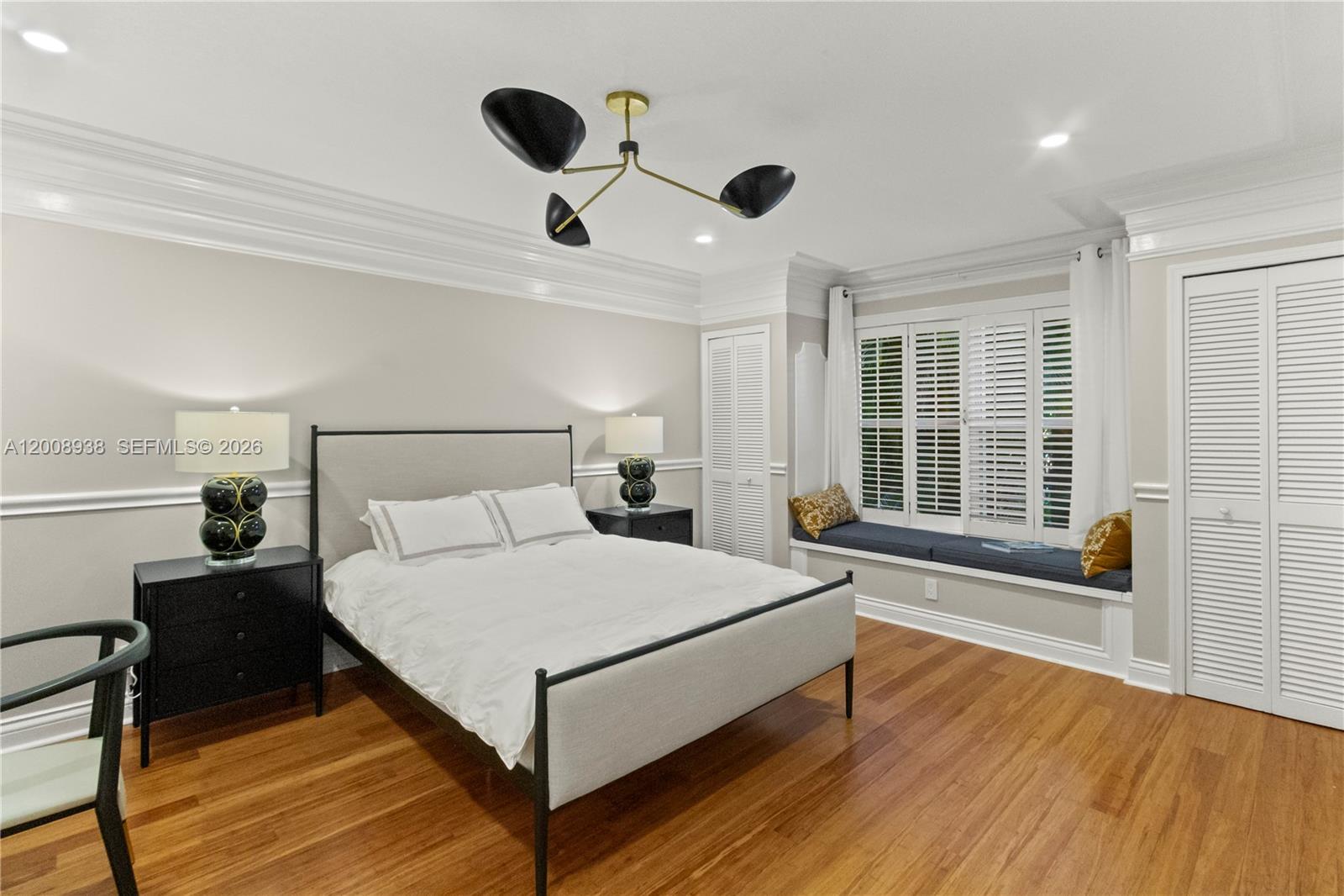 A bedroom features a bed, two nightstands, a window seat, and a modern light fixture — 4161 S Us Highway 1 # H1, Jupiter FL 33477, JUPITER, FL