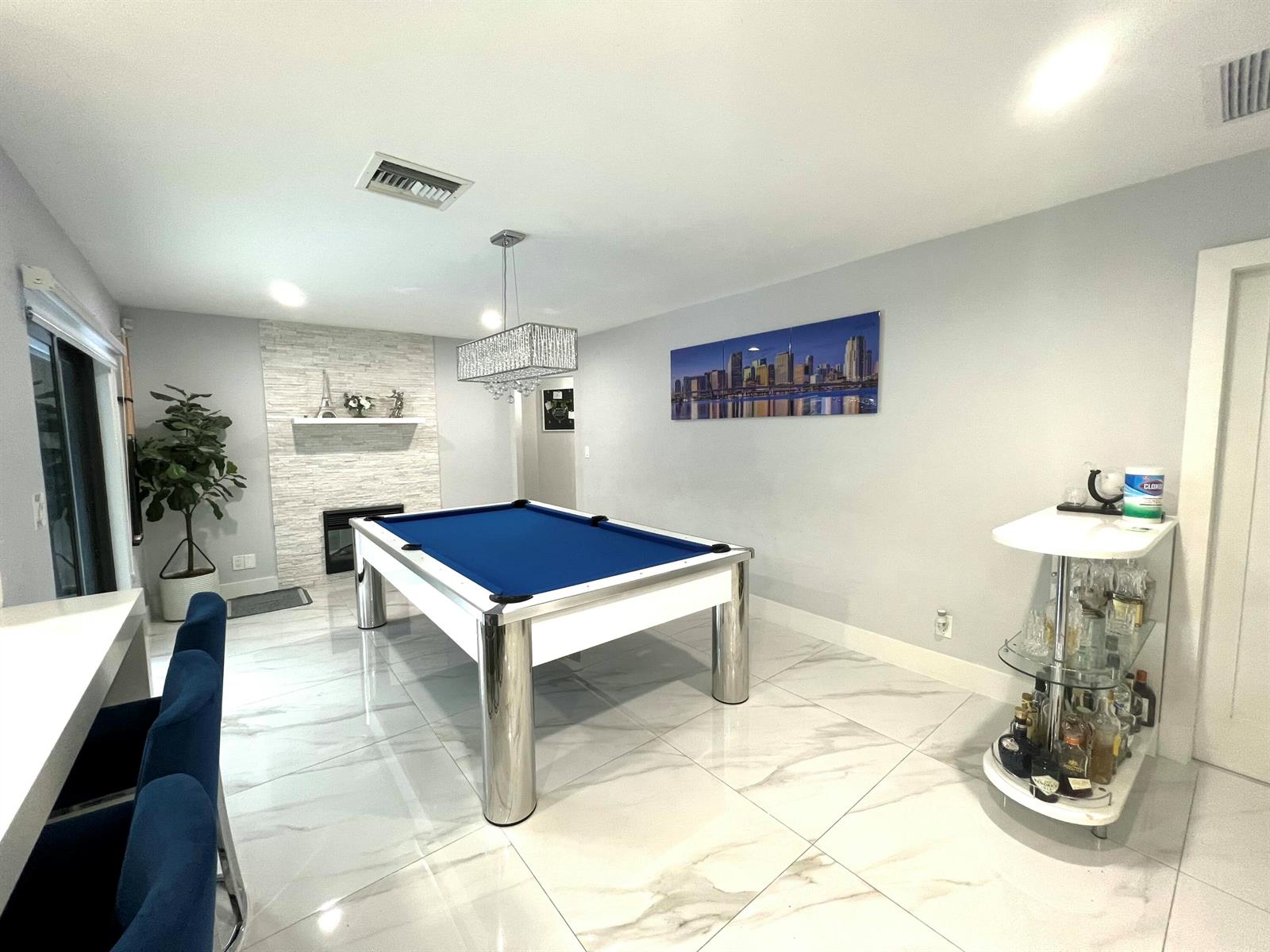 A game room features a blue pool table, white tile flooring, and a stone fireplace — 625 W Tropical Way, Plantation FL 33317, PLANTATION, FL