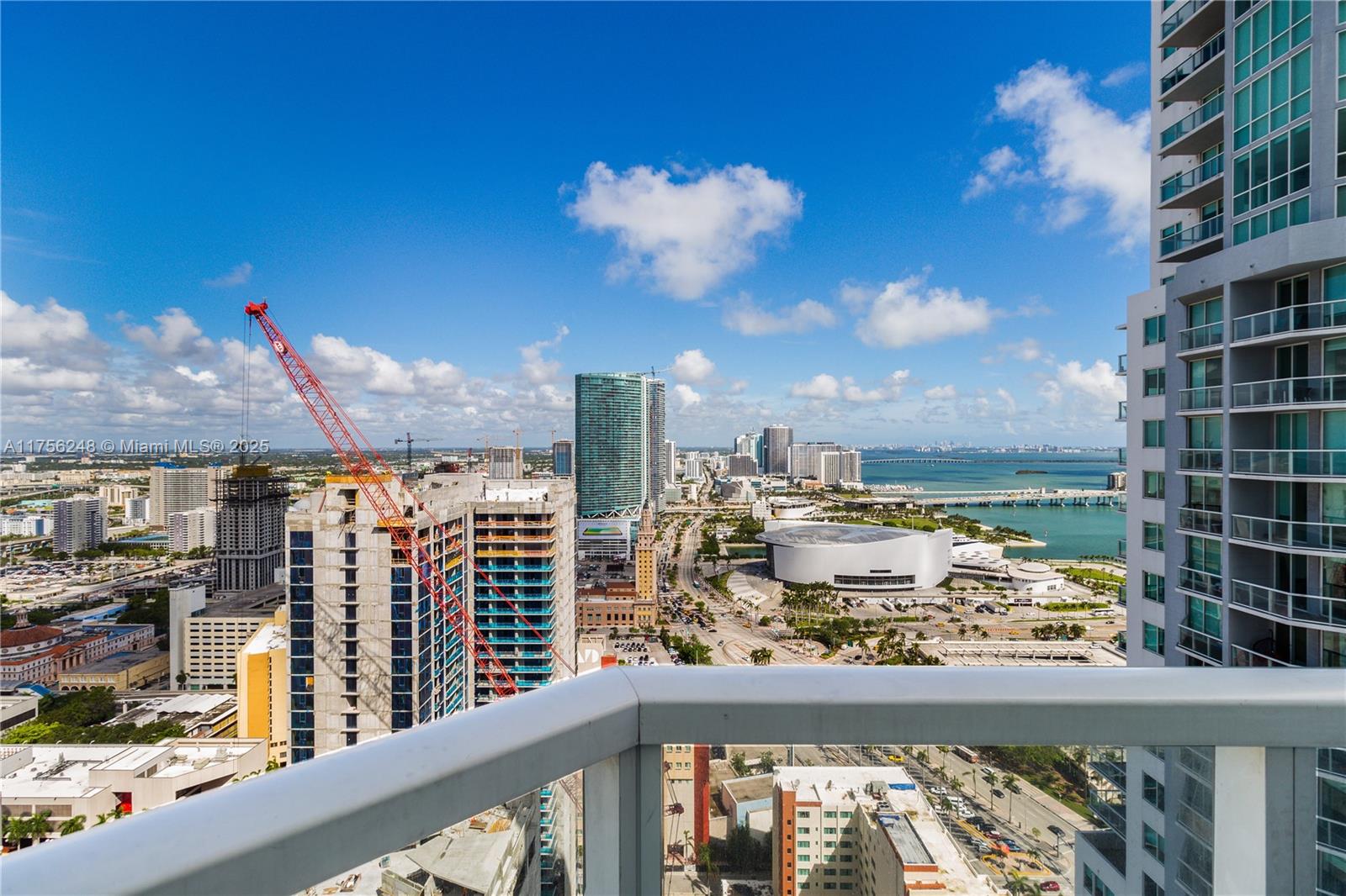 An elevated view shows a city skyline, a construction site with a crane, and water — 253 NE 2nd St # 3702, Miami FL 33132, MIAMI, FL