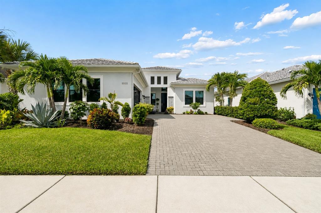 A single-story house with a paved driveway, palm trees, and a landscaped front yard — 9005 BERNINI PLACE, SARASOTA, FL
