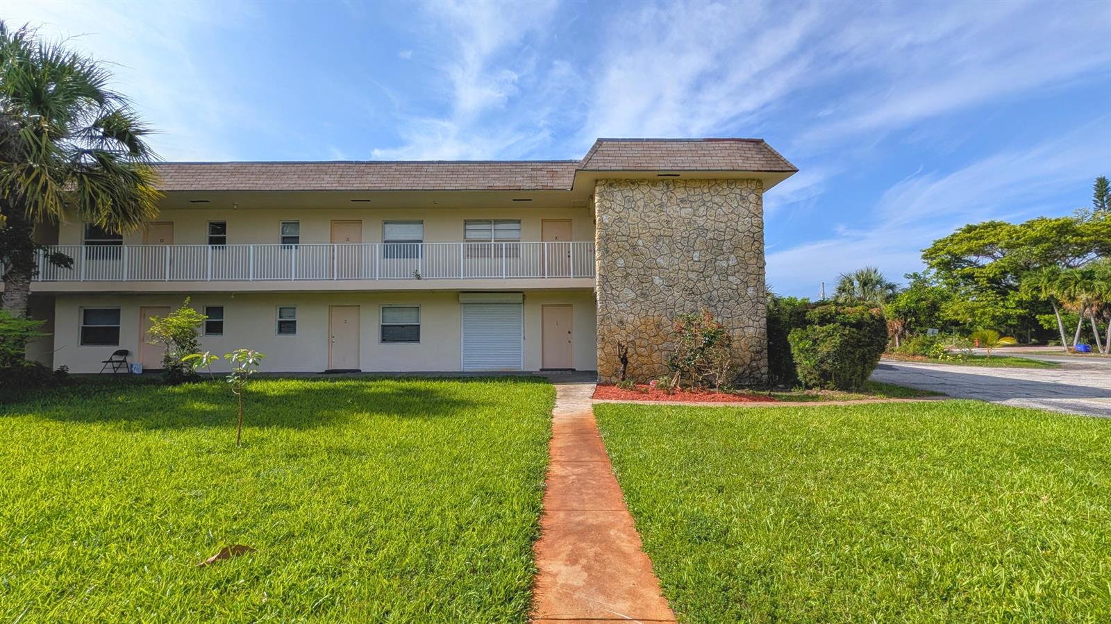 A two-story apartment building with a stone facade and a walkway through the lawn — 2301 SE 4th Street # 12, Boynton Beach FL 33435, BOYNTON BEACH, FL