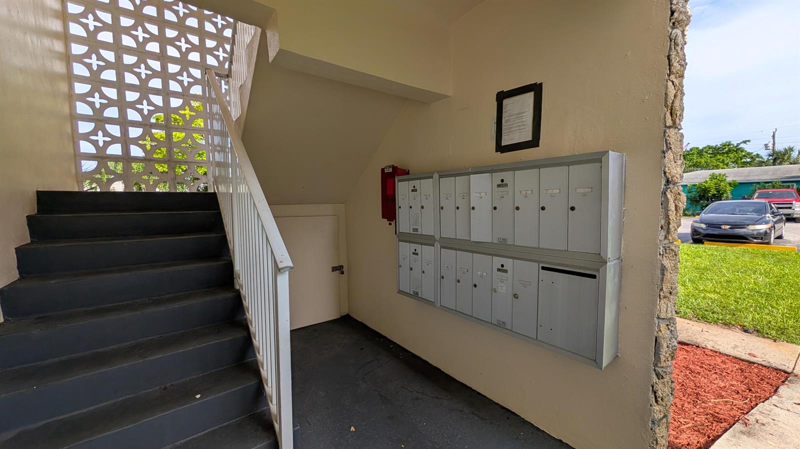 An outdoor stairwell features a metal mailbox bank, a small door, and decorative concrete blocks — 2301 SE 4th Street # 12, Boynton Beach FL 33435, BOYNTON BEACH, FL