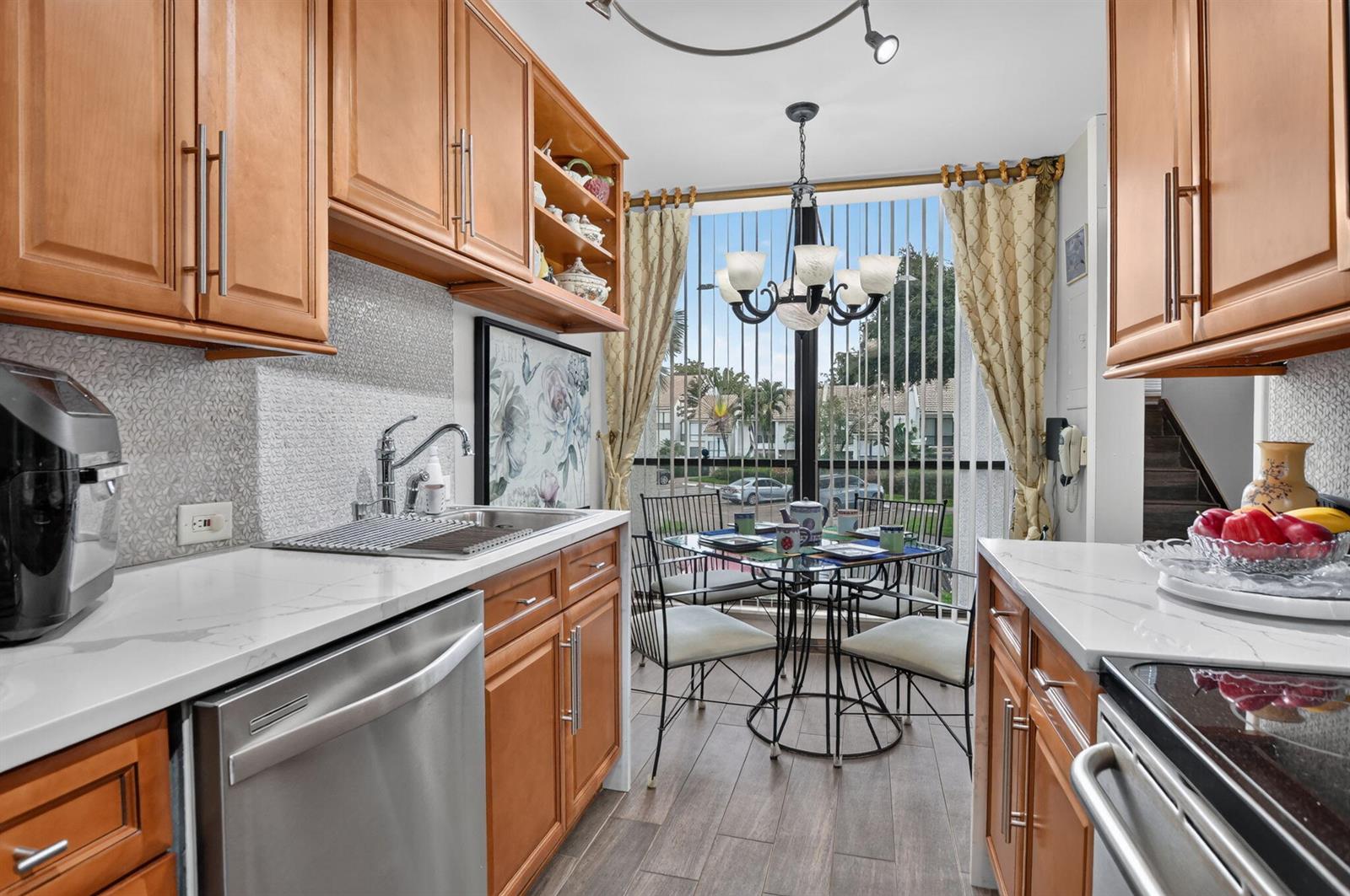 A kitchen with wood cabinets, stainless steel appliances, and a dining area by the window — 2805 Bridgewood Drive, Boca Raton FL 33434, BOCA RATON, FL