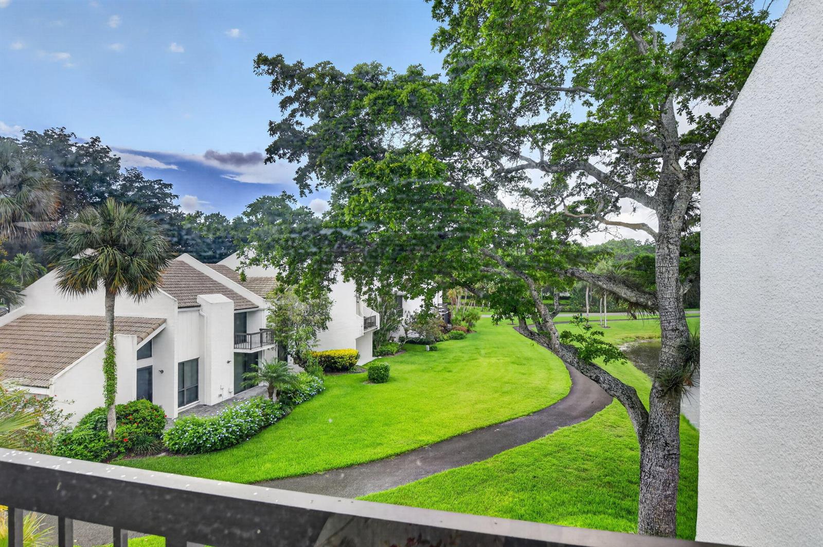 An elevated view of a grassy courtyard with a winding path and residential buildings — 2805 Bridgewood Drive, Boca Raton FL 33434, BOCA RATON, FL