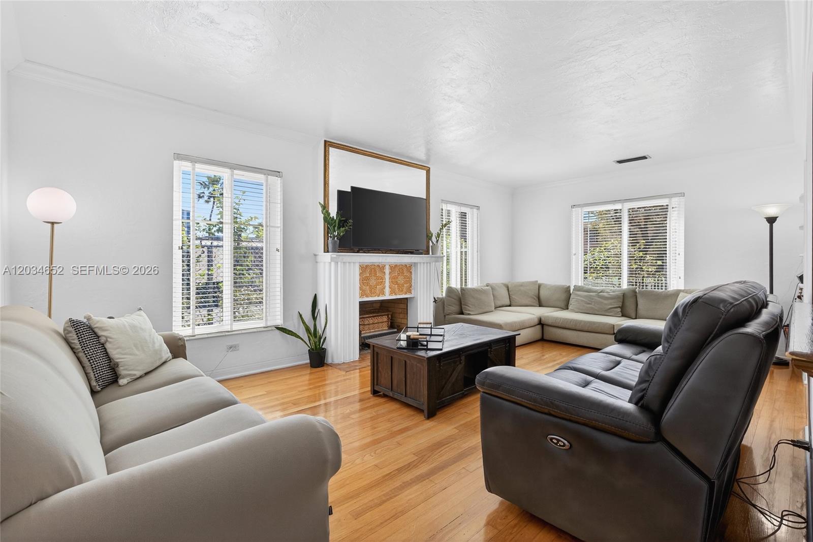 A living room features a fireplace, a television, and multiple seating areas on hardwood floors — 2431 SW 4th St, Miami FL 33135, MIAMI, FL