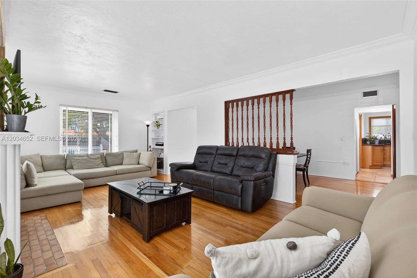 A living room features hardwood floors, white walls, and a wooden room divider — 2431 SW 4th St, Miami FL 33135, MIAMI, FL