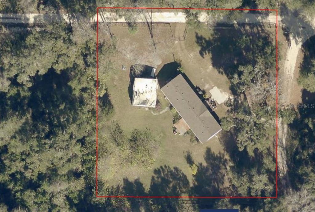 An aerial view shows a house and a detached structure on a fenced wooded lot — 4650 SW 36 STREET, OCALA, FL