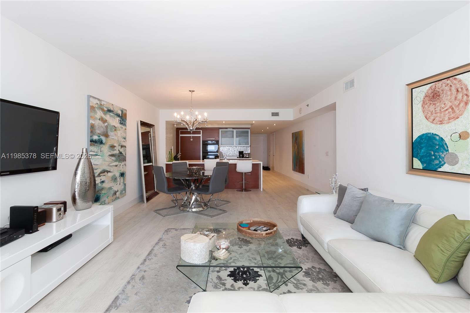 A modern living room and dining area feature white walls, light flooring, and contemporary furniture — 1830 S OCEAN DR. # 3711, Hallandale Beach FL 33009, HALLANDALE BEACH, FL