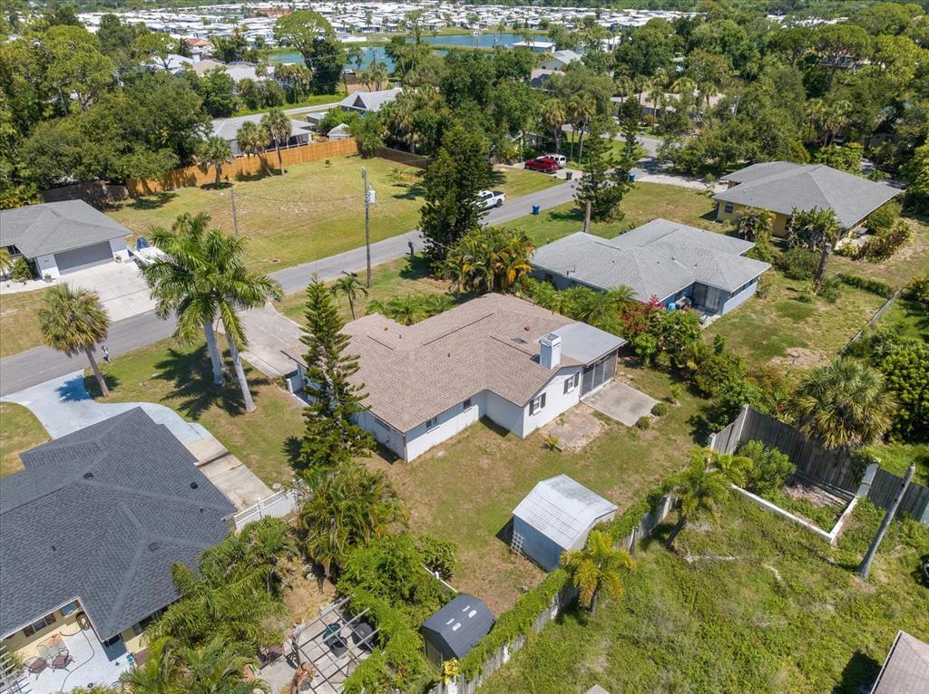 An aerial view shows a single-story house with a brown roof and a backyard shed — 1236 GAYLE AVE, NOKOMIS, FL