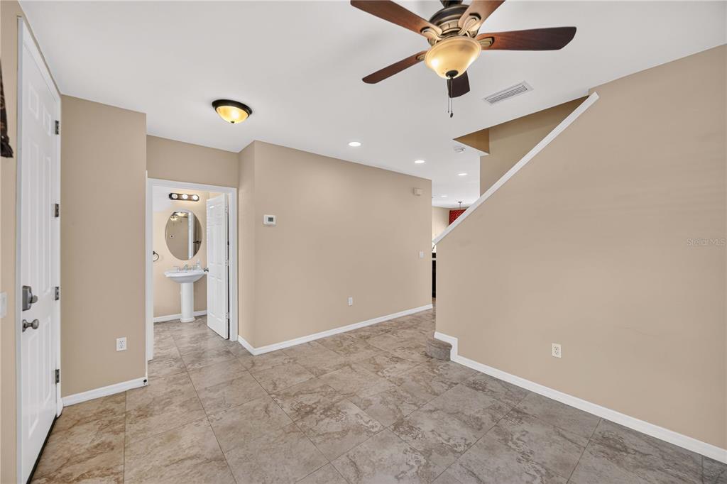 An entryway with tiled floors, a ceiling fan, and a doorway leading to a bathroom — 5653 WHITEHEAD STREET, BRADENTON, FL