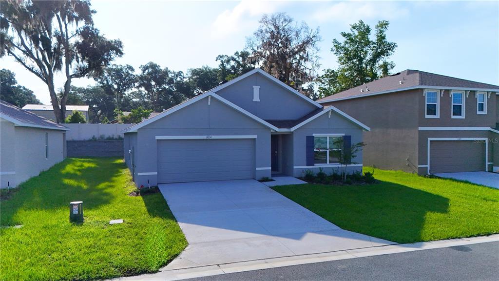 A single-story gray house with a two-car garage and a front lawn — 11331 SE 72ND COURT, BELLEVIEW, FL