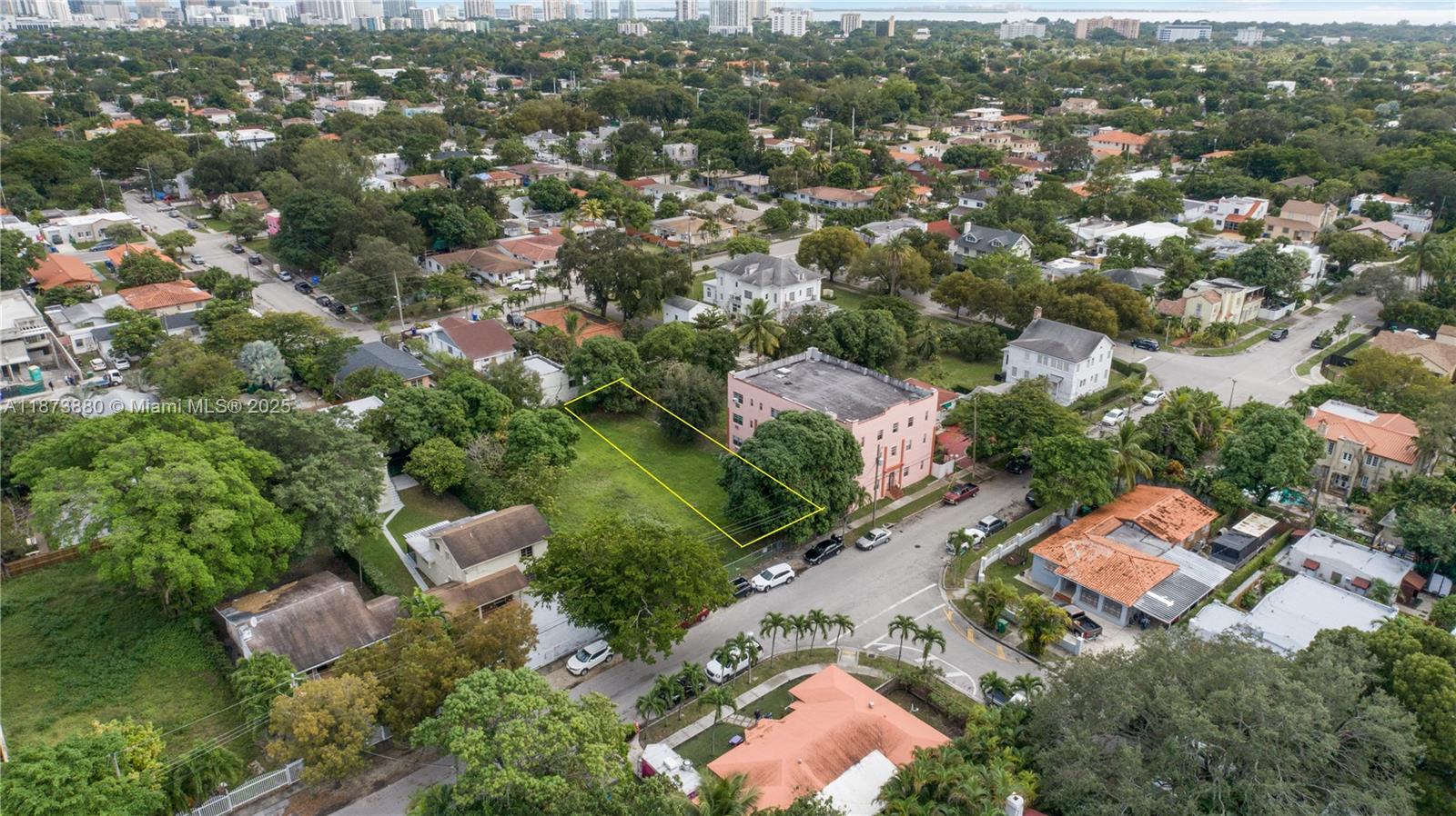 An aerial view shows a vacant rectangular lot outlined in yellow next to a pink building — 1001 SW 15th Ave, Miami FL 33135, MIAMI, FL