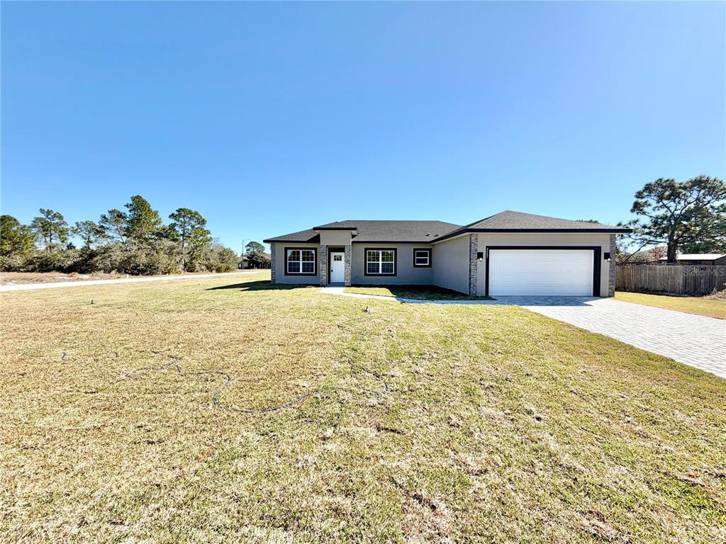 A single-story house with a gray exterior, a two-car garage, and a paved driveway — 4662 SAN IGNACIO DRIVE, SEBRING, FL