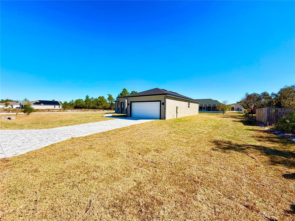 A single-story house with a white garage door and a paved driveway in a yard — 4662 SAN IGNACIO DRIVE, SEBRING, FL