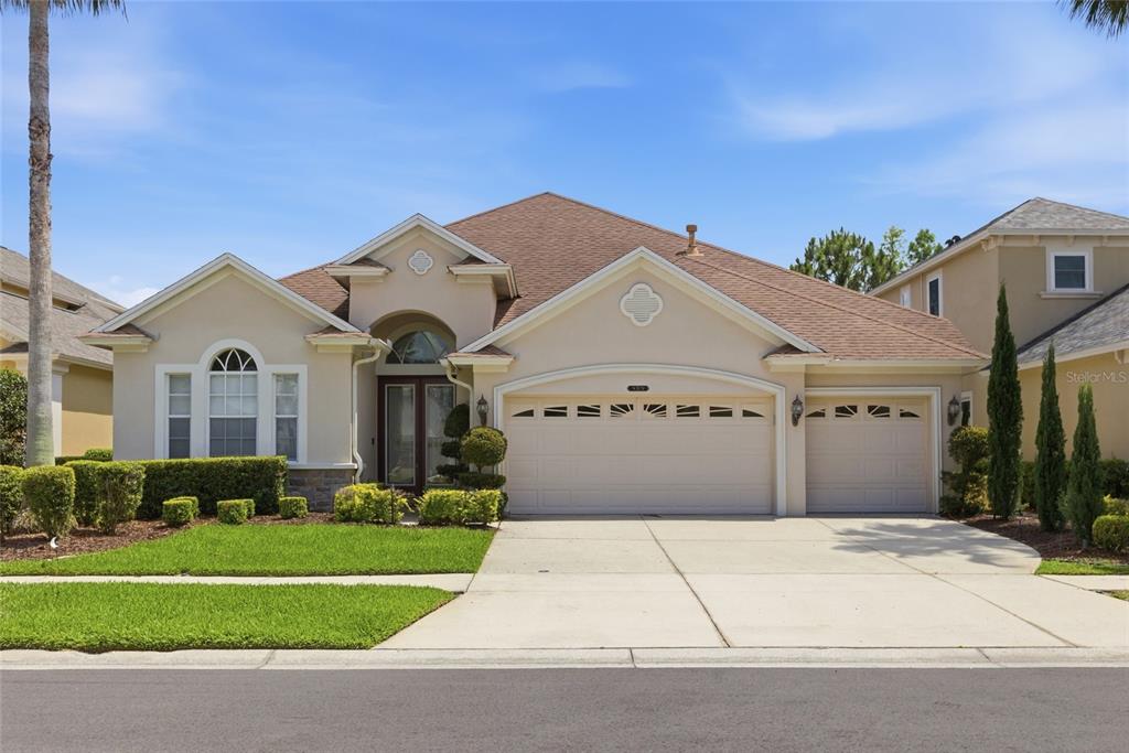 A single-story suburban house with a beige stucco exterior, brown roof, and three-car garage — 8309 OLD TOWN DRIVE, TAMPA, FL