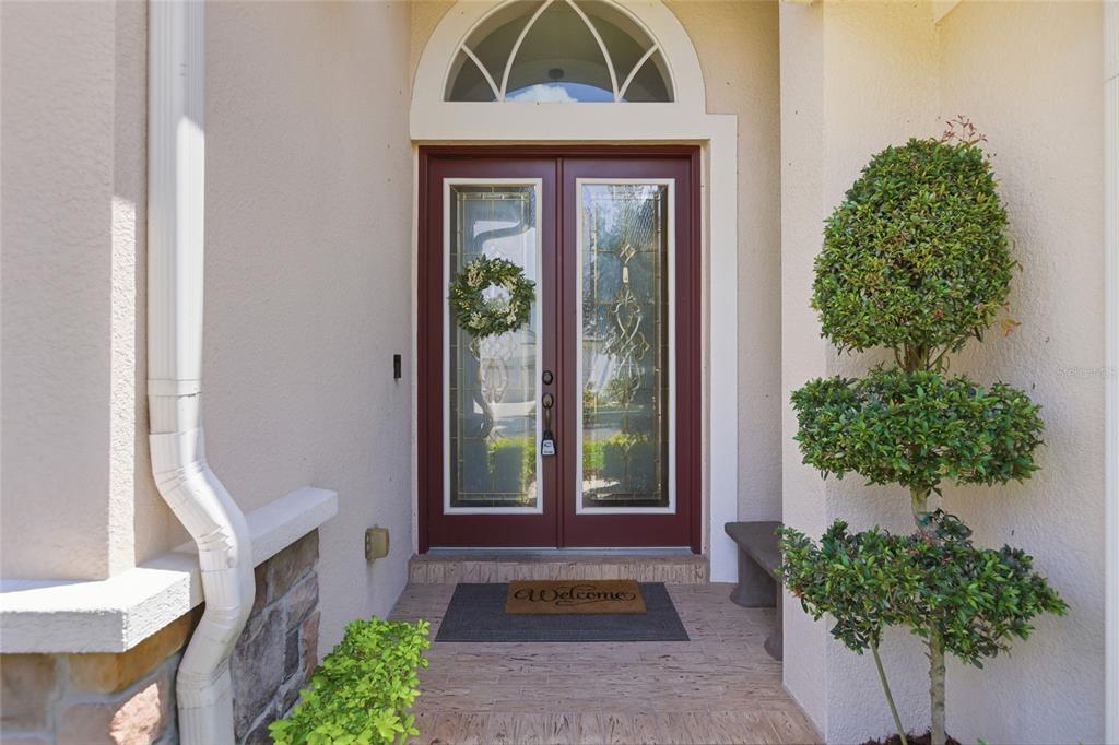A front entryway features a red double door with glass panels and a welcome mat — 8309 OLD TOWN DRIVE, TAMPA, FL
