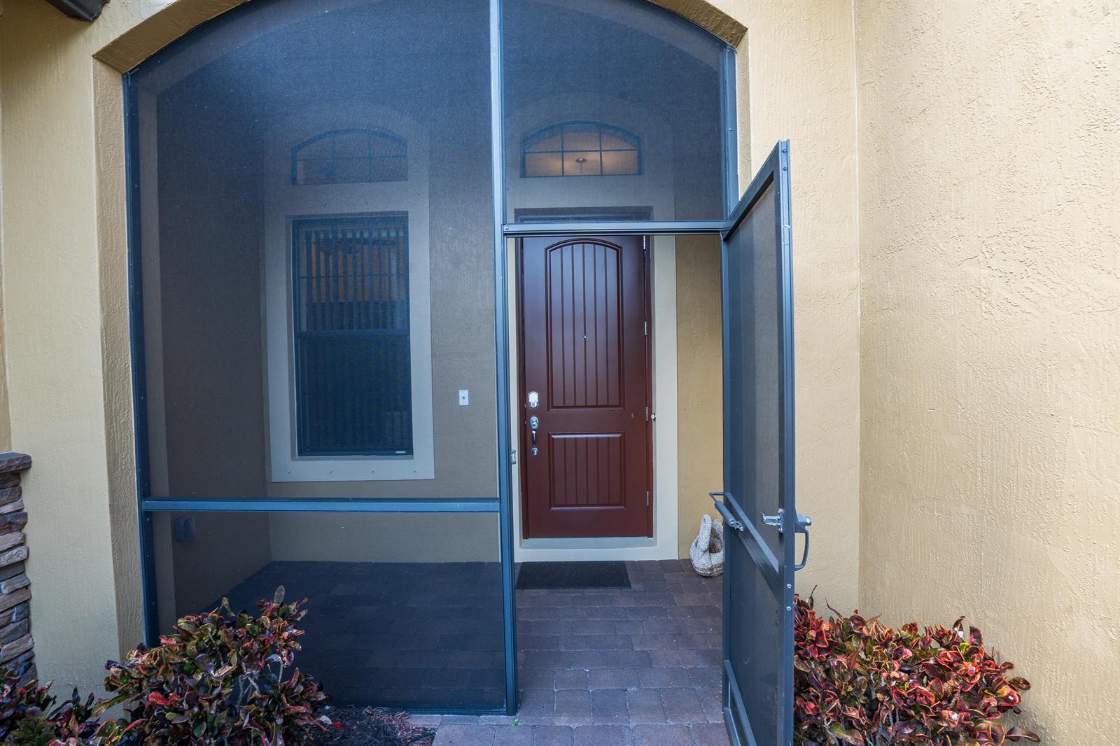 A brown front door is visible behind a black metal screen door and enclosure — 4127 Siena Circle, Wellington FL 33414, WELLINGTON, FL