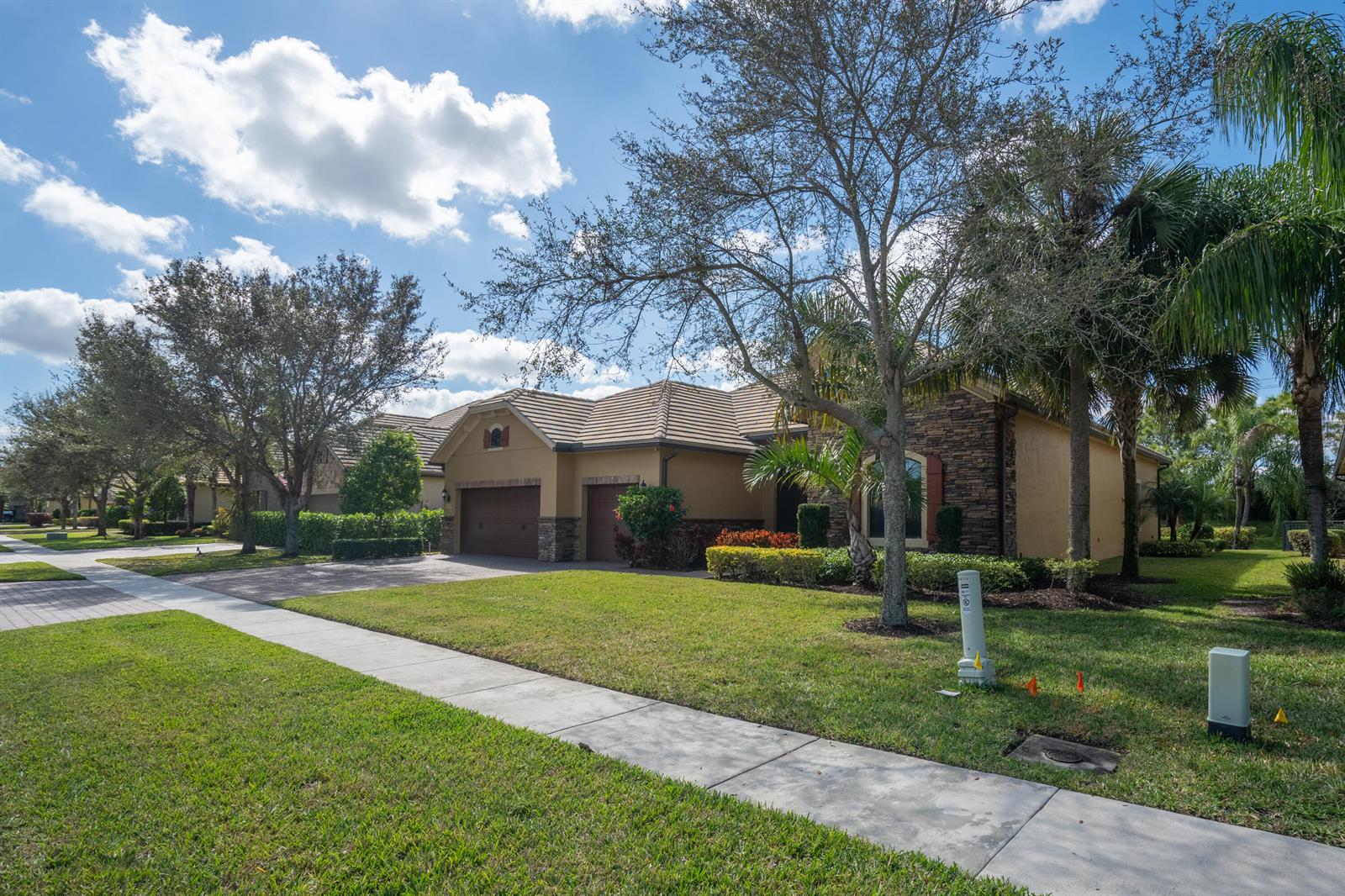 A single-story house with a stone facade, two-car garage, and a landscaped front lawn — 4127 Siena Circle, Wellington FL 33414, WELLINGTON, FL
