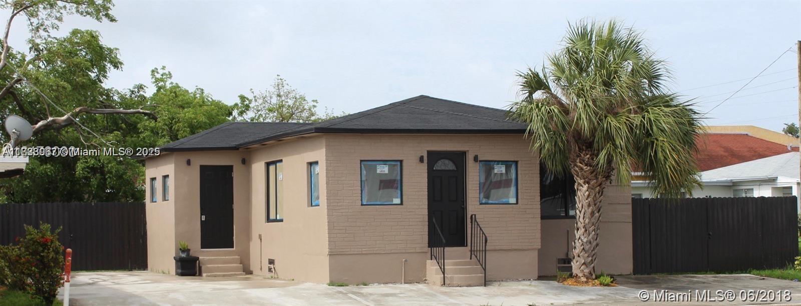 A single-story house with a tan exterior, dark roof, and a palm tree in front — 107 W Pembroke Rd, Hallandale Beach FL 33009, HALLANDALE BEACH, FL