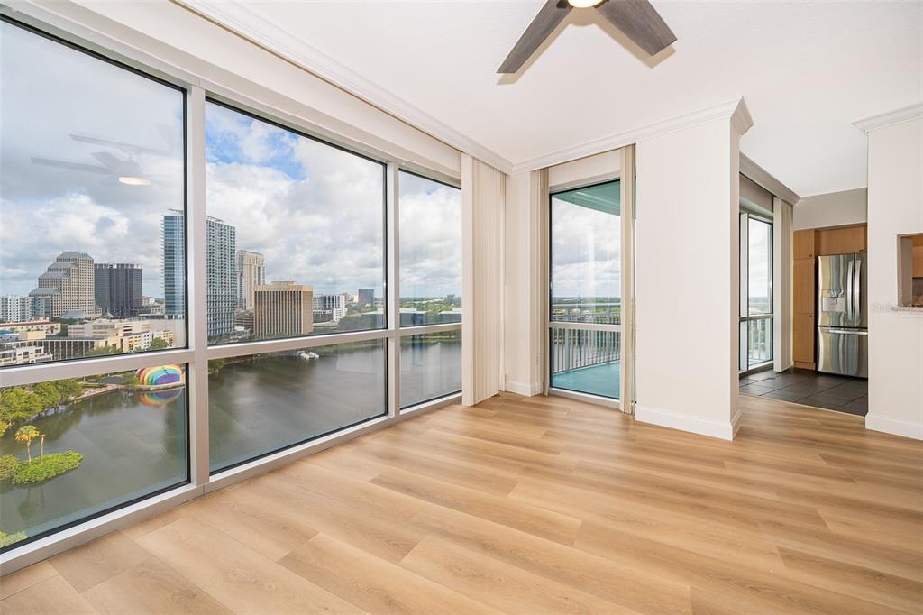 An empty room with light wood floors, floor-to-ceiling windows, and a view of a city — 322 E CENTRAL BOULEVARD UNIT 1602, ORLANDO, FL