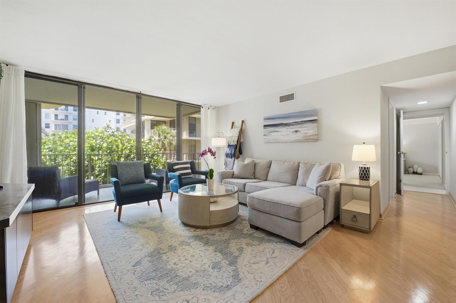 A balcony overlooks a lush green landscape, a tennis court, and a wide blue bay — 3200 S Ocean Boulevard # D203, Palm Beach FL 33480, PALM BEACH, FL