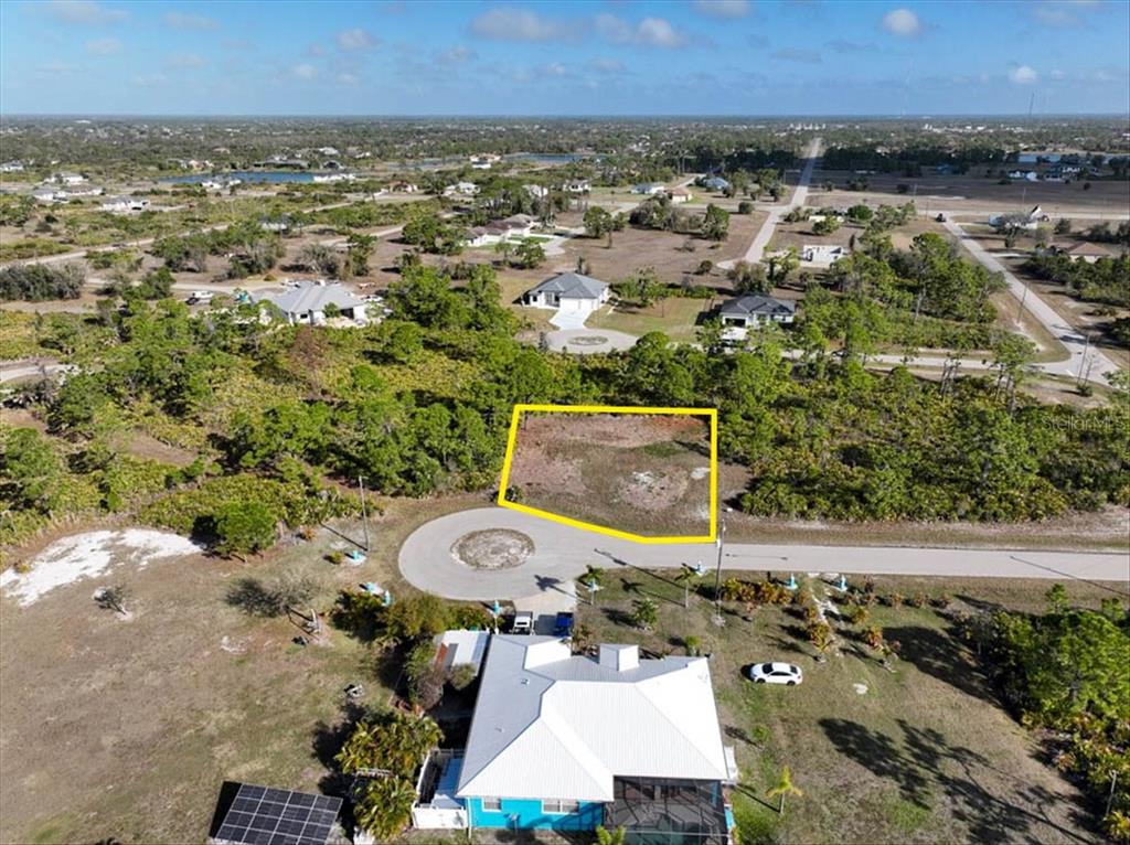 An aerial view shows a vacant, rectangular lot outlined in yellow near a cul-de-sac — 6 BERTH COURT, PLACIDA, FL
