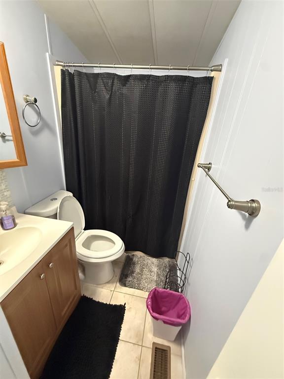 A bathroom features a vanity, toilet, shower with a black curtain, and light blue walls — 3000 CLARCONA ROAD UNIT 2715, APOPKA, FL
