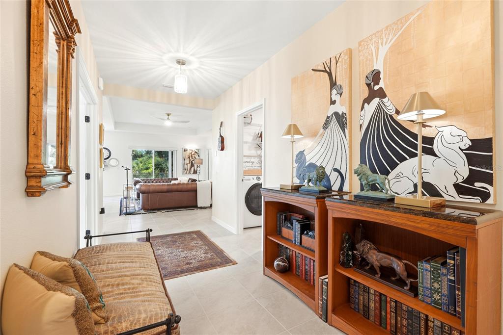 An open-concept kitchen and living area features white cabinetry, leather sofas, and a dining set — 9860 LAST LIGHT GLEN, PARRISH, FL