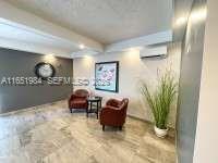 A small lobby area features two brown armchairs, a side table, and a wall clock — 6100 NW 44th St # 405, Lauderhill FL 33319, LAUDERHILL, FL