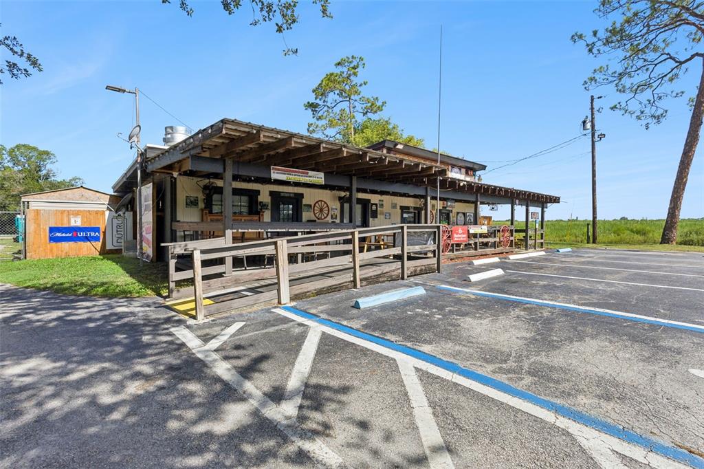 A single-story commercial building with a covered wooden porch and an adjacent parking lot — 36721 COUNTY ROAD 19A, EUSTIS, FL
