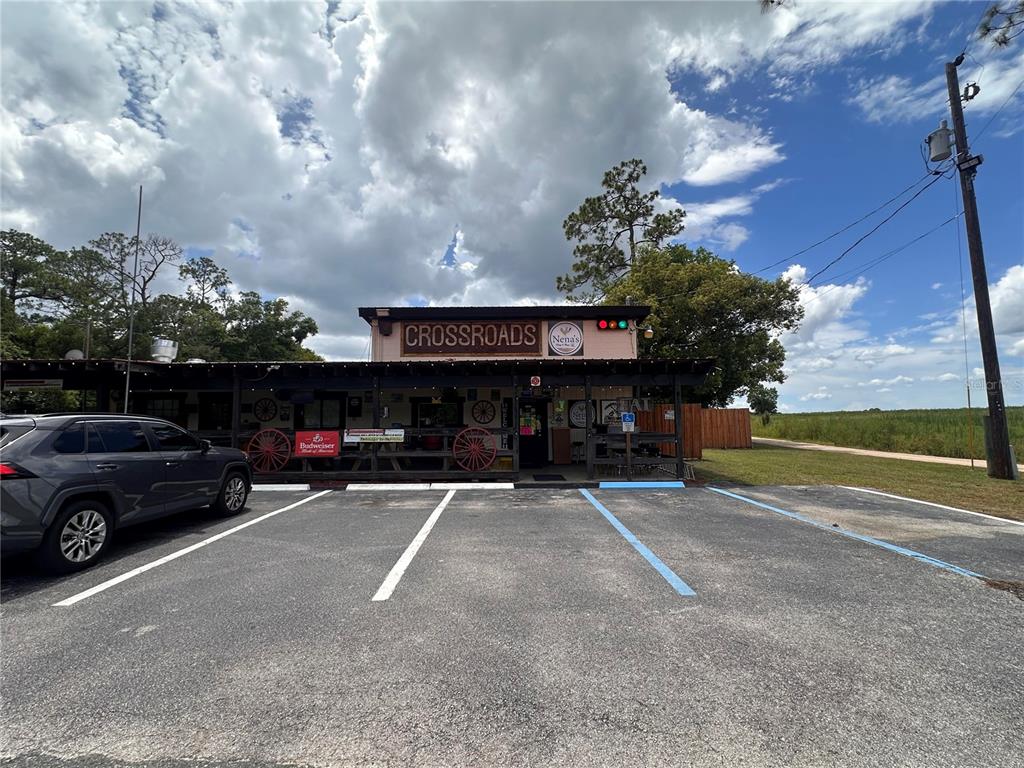 A single-story commercial building with a covered porch and parking lot under a cloudy sky — 36721 COUNTY ROAD 19A, EUSTIS, FL
