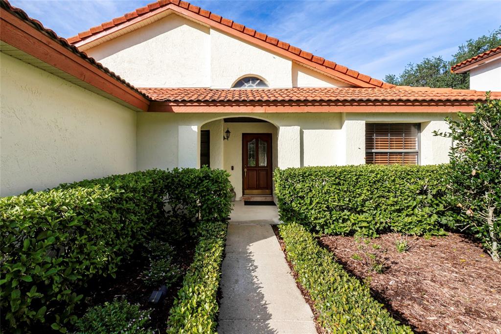 A concrete walkway leads to the front entrance of a house with a tiled roof — 6350 PARSON BROWN DRIVE, ORLANDO, FL