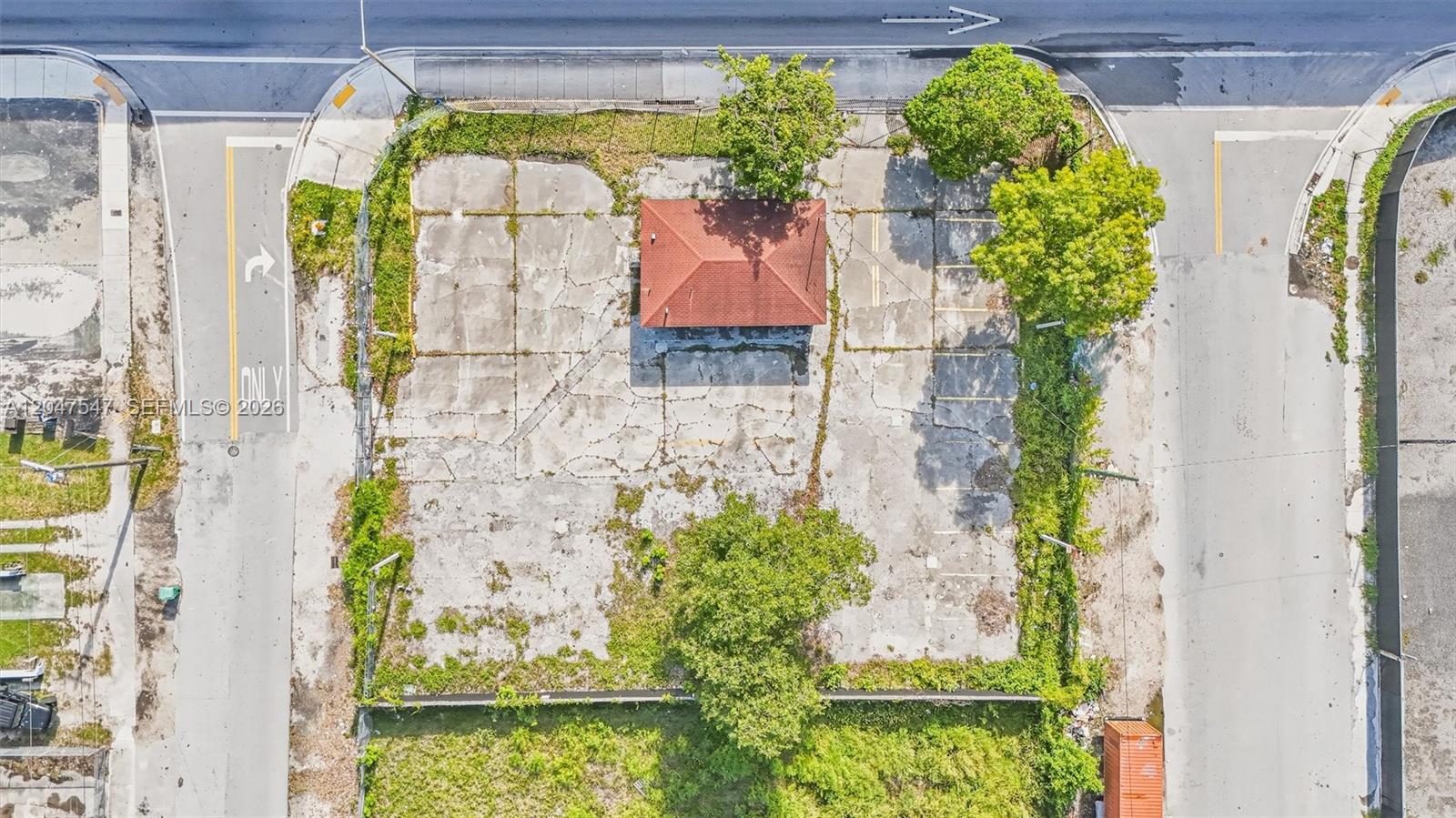 An aerial view shows a small building with a red roof on a paved lot — 6801 NW 27th Ave, Miami FL 33147, MIAMI, FL