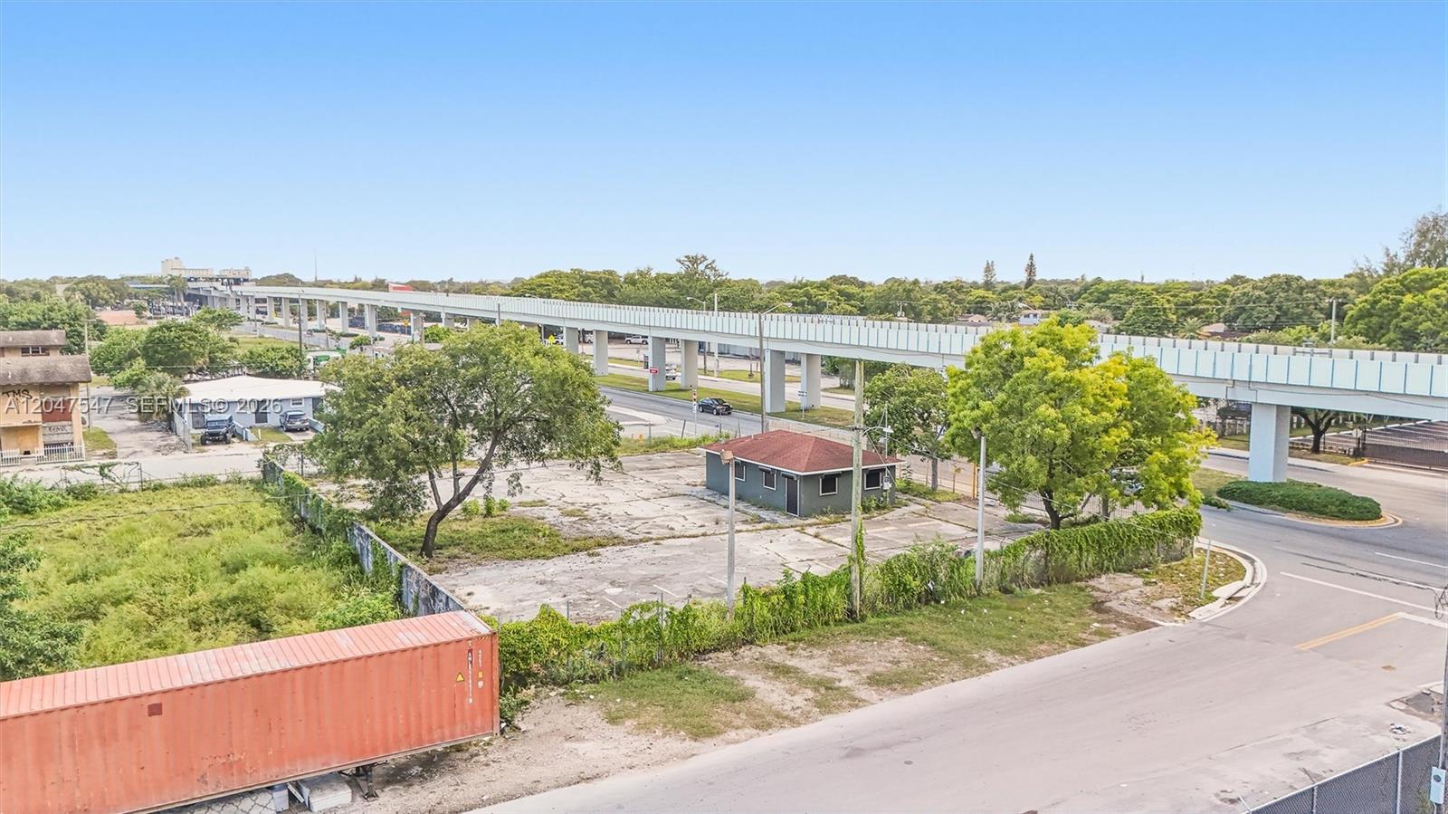 An aerial view shows a small building on a paved lot near an elevated highway — 6801 NW 27th Ave, Miami FL 33147, MIAMI, FL