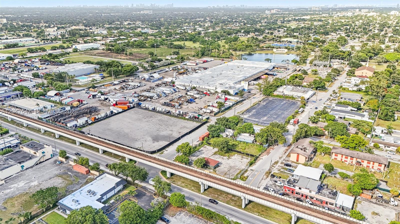 An aerial view shows a large industrial warehouse complex with a rail overpass nearby — 6801 NW 27th Ave, Miami FL 33147, MIAMI, FL