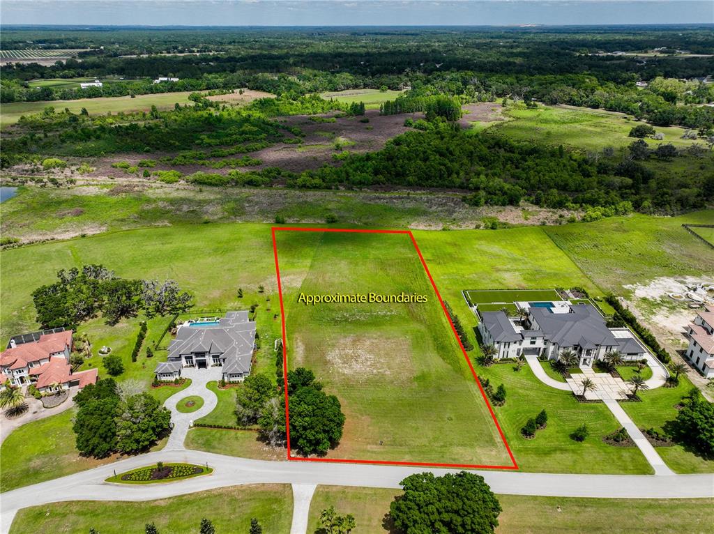 An aerial view shows a vacant rectangular lot outlined in red between two large houses — 12322 STONELAKE RANCH BOULEVARD, THONOTOSASSA, FL