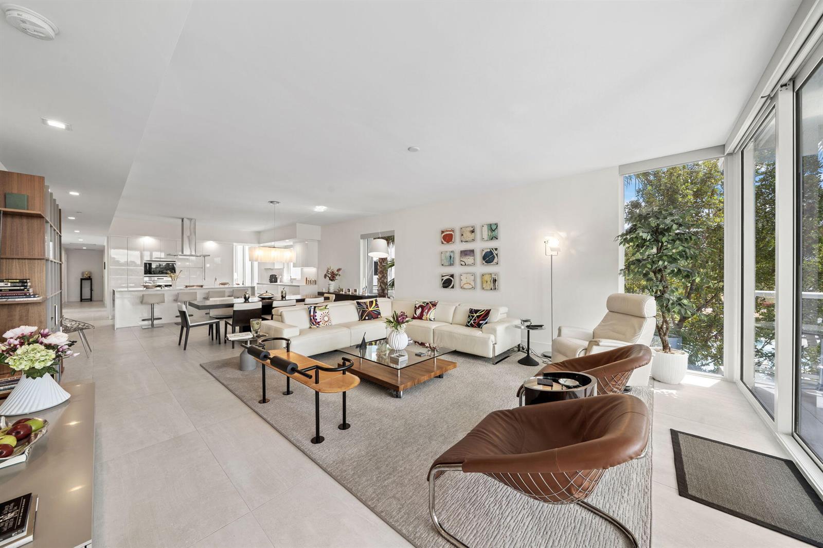 A modern open-concept living and dining area with white tile floors and floor-to-ceiling windows — 20155 Boca West Drive # C201, Boca Raton FL 33434, BOCA RATON, FL