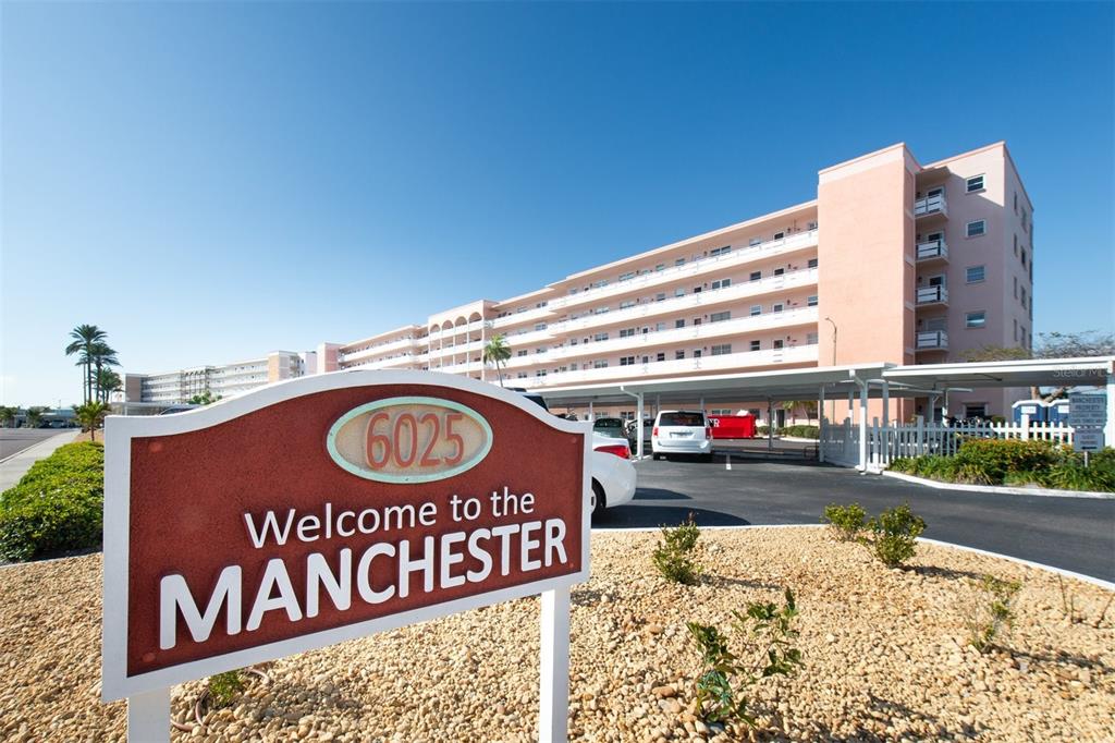 A sign for The Manchester stands in front of a multi-story pink apartment building — 6025 SHORE BOULEVARD S UNIT 405, GULFPORT, FL