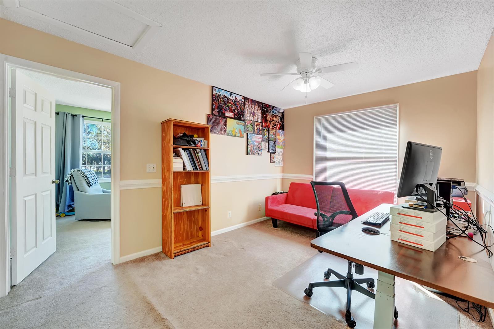 A home office features a desk, a red sofa, a wooden bookshelf, and a ceiling fan — 2008 Normandy Circle, West Palm Beach FL 33409, WEST PALM BEACH, FL