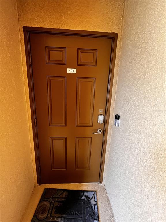 A brown six-panel apartment door labeled 403 with a keypad lock and doorbell camera — 6515 GRAND ESTUARY TRAIL UNIT 403, BRADENTON, FL