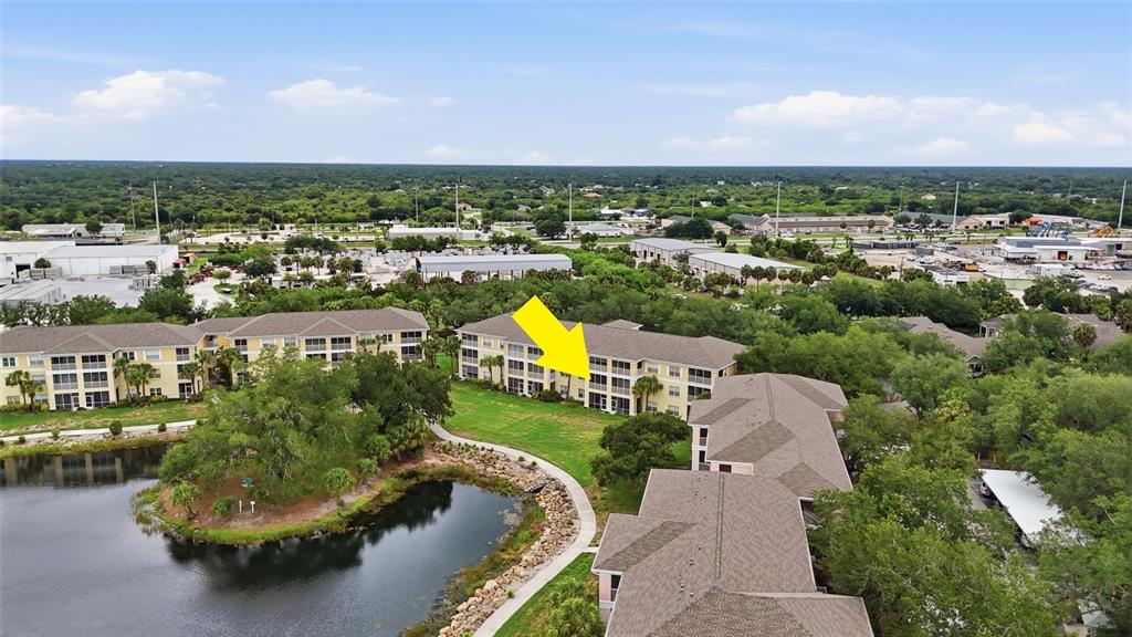 An aerial view shows a multi-story apartment building with a yellow arrow pointing toward it — 19355 WATER OAK DRIVE UNIT 303, PORT CHARLOTTE, FL