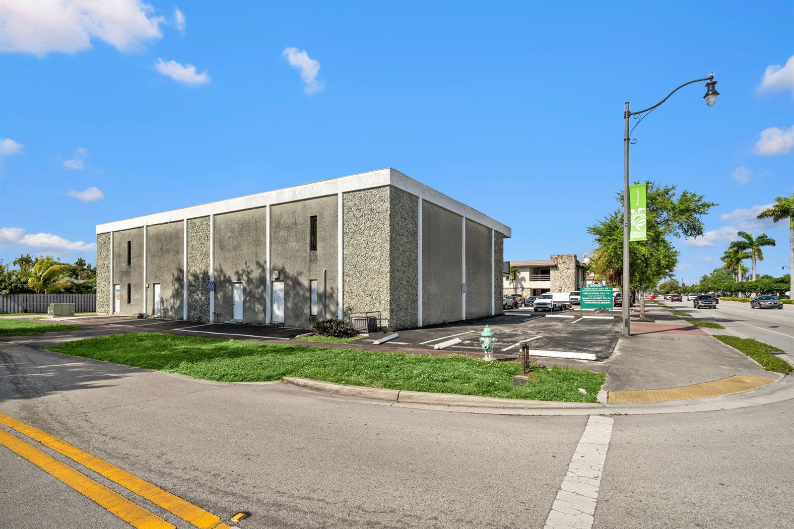A two-story commercial building with a textured facade stands next to a parking lot — 5000 Hollywood Boulevard, Hollywood FL 33021, HOLLYWOOD, FL