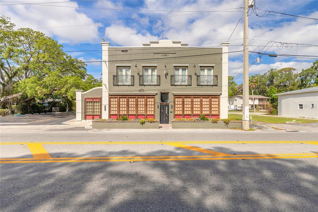 A two-story building with a green facade, ground-floor windows, and four upper-level balconies — 1112 RIVERSIDE DRIVE, DAYTONA BEACH, FL