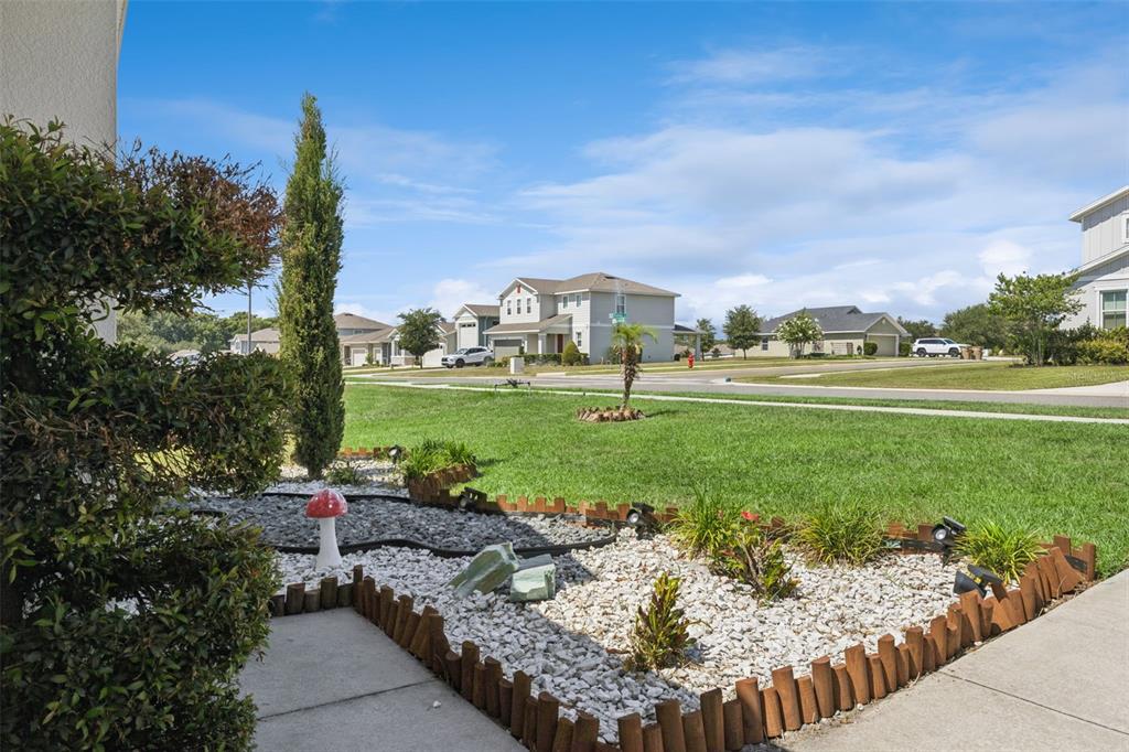 A front yard features a rock garden with a mushroom ornament and a small tree — 31736 BROADWATER AVENUE, LEESBURG, FL